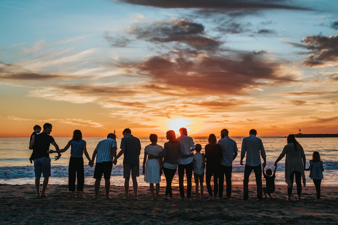 Familia reunida junto al mar al atardecer